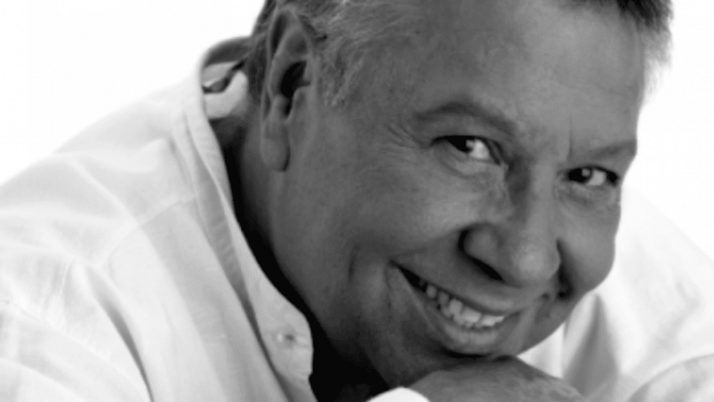 La cara íntima de Moncho. Primer plano, sonriendo y con la barbilla apoyada en su mano