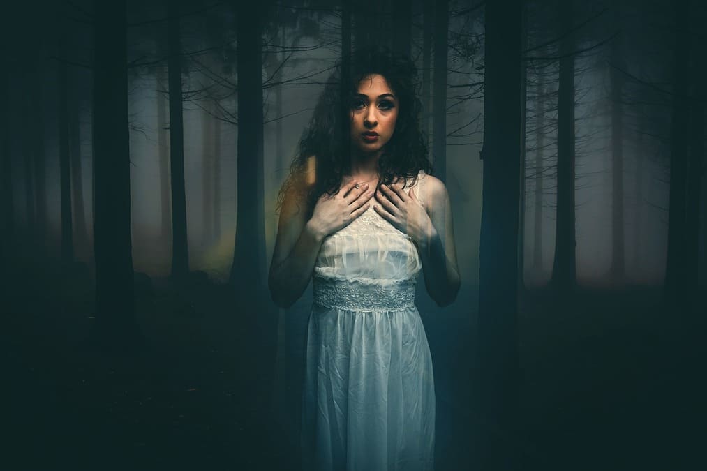 Mujer semitrasparente con bosque oscuro atrás